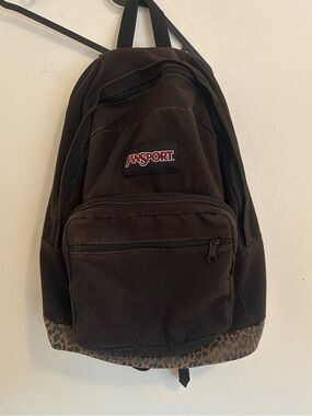Brown Jansport back pack with a cheetah print suede bottom